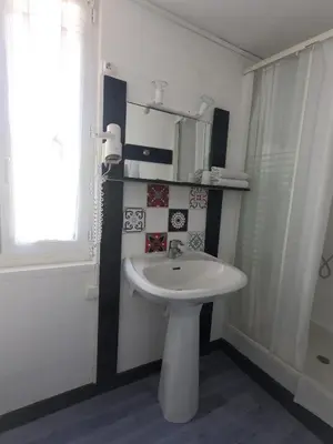 a bathroom with a white sink and a window at Le palais, hôtel - restaurant in Apt
