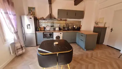 a kitchen with a table and a refrigerator at Sunny Apartment with Nice View in History City Center in Aix-en-Provence