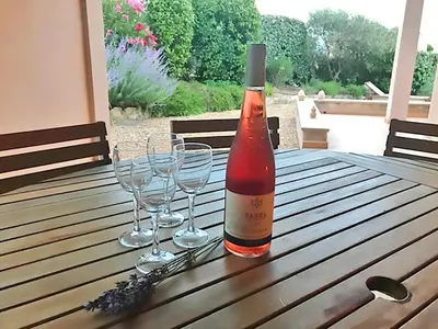 a bottle of wine sitting on a wooden table with wine glasses at Villa in Saumane near Golf Course and Pool in Saumane-de-Vaucluse
