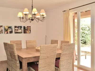 a dining room with a wooden table and chairs at Villa in Saumane near Golf Course and Pool in Saumane-de-Vaucluse