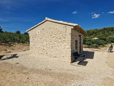 a small stone building in the middle of a field at Bastide Bellugue Maison d'hôtes réseau Bienvenue à La Ferme à 3 minutes de Lourmarin in Cadenet