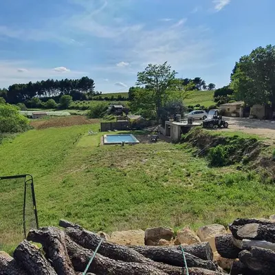 a view of a field with a swimming pool at Bastide Bellugue Maison d'hôtes réseau Bienvenue à La Ferme à 3 minutes de Lourmarin in Cadenet