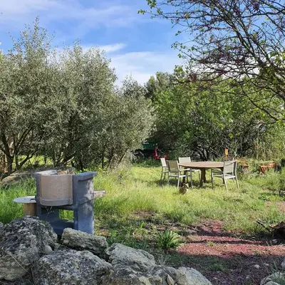 a picnic table and a table and chairs in a field at Bastide Bellugue Maison d'hôtes réseau Bienvenue à La Ferme à 3 minutes de Lourmarin in Cadenet