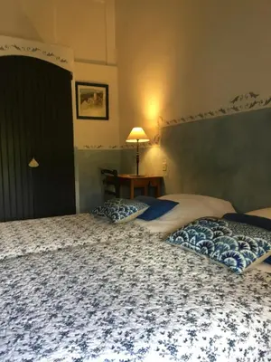 a bedroom with two beds and a lamp on a table at Domaine La Condamine CRILLON LE BRAVE in Crillon-le-Brave