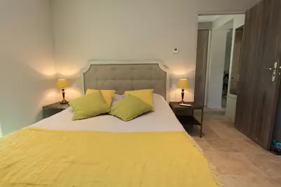 a bedroom with a large yellow bed with two yellow pillows at Mas De Gordes in Gordes
