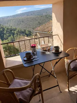 a table on a balcony with a view at Rose in Bonnieux