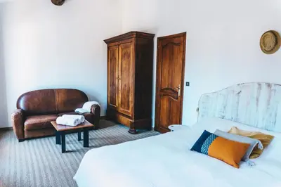 a bedroom with a bed and a chair at Villa in Provence with private pool in LʼIsle-sur-la-Sorgue