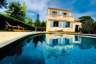 a house and a swimming pool in front of a house at Villa in Provence with private pool in LʼIsle-sur-la-Sorgue