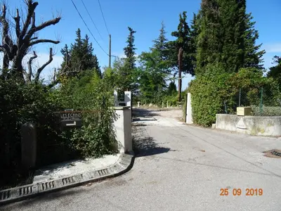 an empty street with a fence and trees at Les Ecrins d'Aix-en-Provence in Aix-en-Provence