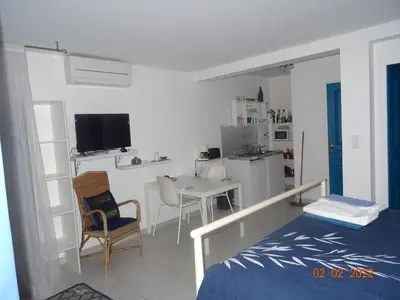 a bedroom with a bed and a table and a kitchen at Les Ecrins d'Aix-en-Provence in Aix-en-Provence