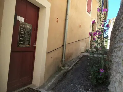 a door to a building with flowers on the side at L'Oustaou de Rose in Bonnieux