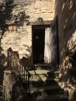 an entrance to a stone building with a gate and stairs at L'Oustaou de Rose in Bonnieux
