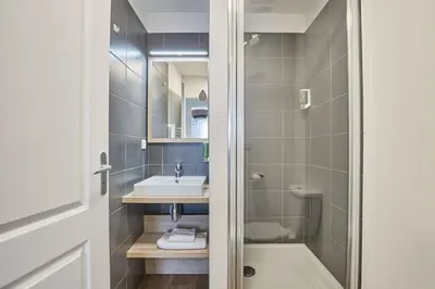 a bathroom with a shower and a sink and a tub at Appart'hôtel Odalys City - Aix en Provence Ouest in Aix-en-Provence
