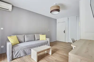 a living room with a couch and a table at Appart'hôtel Odalys City - Aix en Provence Ouest in Aix-en-Provence