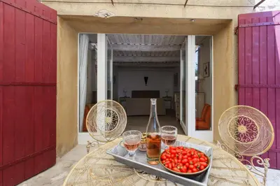a table with glasses of wine and a tray of tomatoes at La Louvière des Bruyères in Robion en Luberon