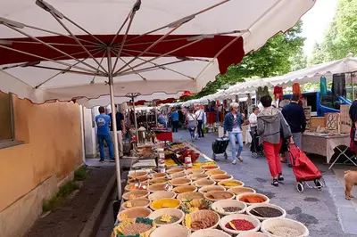 a market with many bowls of food on a street at Envies en Lubéron in Saignon