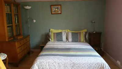 a bedroom with a bed and a green wall at Coin Secret in Murs