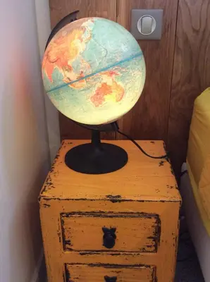 a globe sitting on top of a wooden dresser at Les intérieurs d'Angèle in Pernes-les-Fontaines