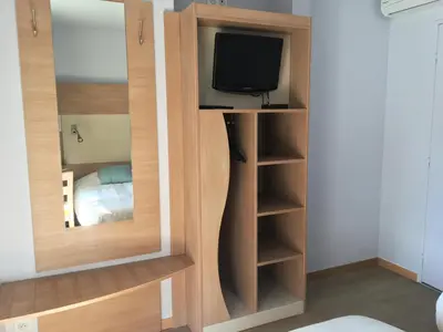 a room with a tv and a closet with a mirror at Hotel Cantosorgue in LʼIsle-sur-la-Sorgue