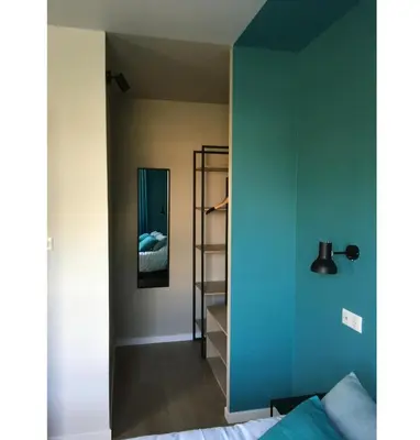 a bedroom with a blue wall and a mirror at Hotel Cantosorgue in LʼIsle-sur-la-Sorgue