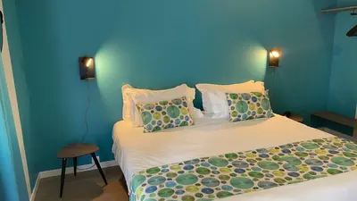 a bedroom with a bed with blue walls at Hotel Cantosorgue in LʼIsle-sur-la-Sorgue