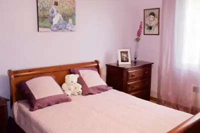 a teddy bear sitting on a bed in a bedroom at Les murmures du Temps Villa 3 Chambres avec Piscine in Carpentras