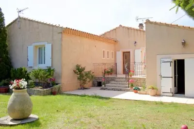 a house with a yard with a vase in the grass at Les murmures du Temps Villa 3 Chambres avec Piscine in Carpentras