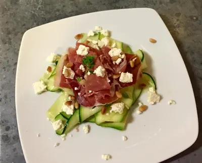 a white plate with a salad with meat and cheese at Le Posterlon in Caumont-sur-Durance