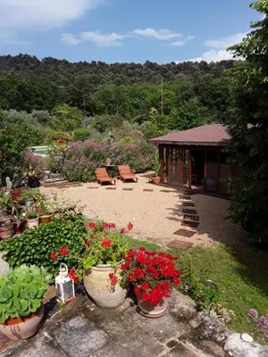 a garden with pots of flowers and a gazebo at Le Paradis in Vaugines