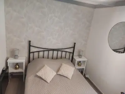 a bedroom with a bed with two pillows and a mirror at Maisonnette in Carpentras