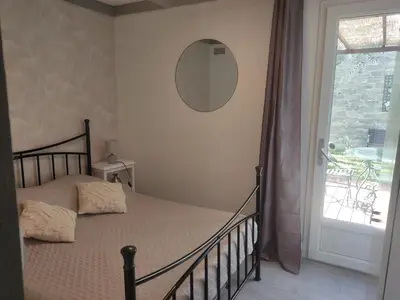 a bedroom with a bed with a mirror on the wall at Maisonnette in Carpentras