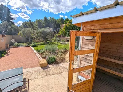 a small wooden building with a door in a garden at Le Panorama des Alpilles in Aureille