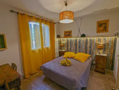 a bedroom with a bed with yellow pillows at Le Panorama des Alpilles in Aureille