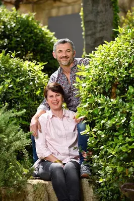 a man sitting next to a woman sitting on a bench at Les Mazets de Marie de Jules in Eyragues