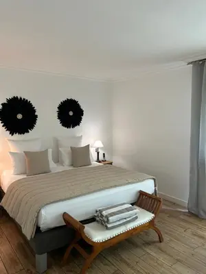 a bedroom with a large bed with a bench and mirrors at Le Mas Angelussi - Le Clos du Soleil in Salon-de-Provence