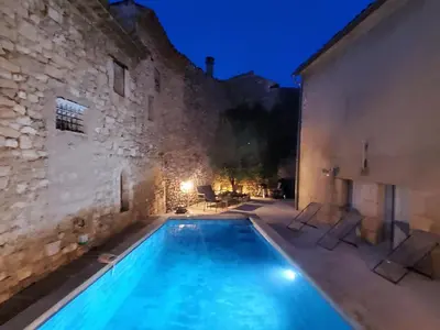a swimming pool in front of a building at night at La maison Bleue in Céreste