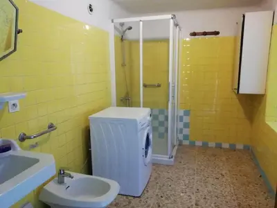 a yellow bathroom with a toilet and a sink at La maison Bleue in Céreste
