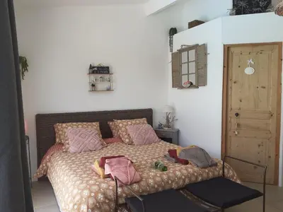 a bedroom with a bed with pink pillows at La Thomalie in Crillon-le-Brave