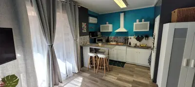 a small kitchen with blue walls and a counter at BlueBird in Cavaillon