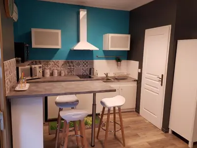 a kitchen with a counter and stools in it at BlueBird in Cavaillon