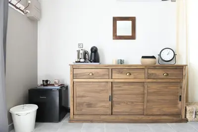 a bathroom with a wooden dresser with a clock on it at Chambre d'hôtes du Charme Provençal in Sénas