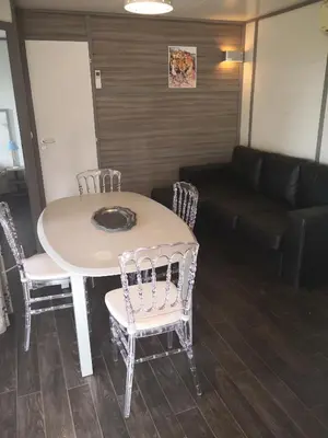 a table and chairs in a living room with a couch at La Colline des Ocres Village de vacances 3 étoiles in Apt