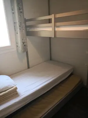 a bunk bed in a small room with a window at La Colline des Ocres Village de vacances 3 étoiles in Apt