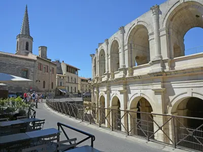 an old building with tables and a church in the background at Mas in Eygalières with Heated Pool in Eygalières
