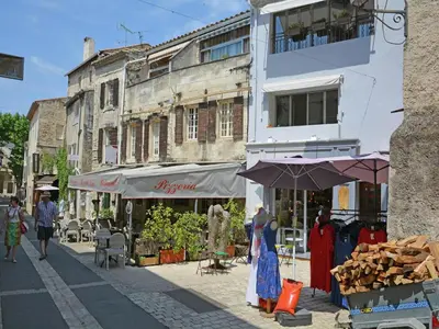 a group of people walking down a street next to a building at Mas in Eygalières with Heated Pool in Eygalières