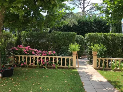 a wooden fence with flowers in a garden at Villa Les Cedres in Aix-en-Provence