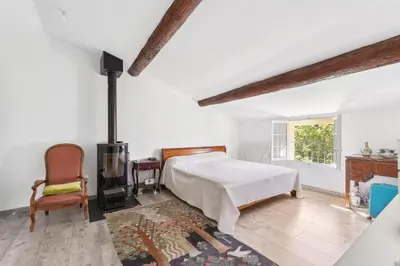 a white bedroom with a bed and a fireplace at Villa Les Cedres in Aix-en-Provence
