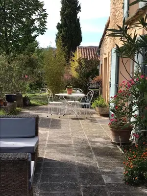 a patio with a table and chairs in a yard at Oustau du Ventoux in Bédoin
