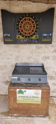a dart board on top of a box on a wall at Le Mas de la Tortue (Plain Pied) in Caromb