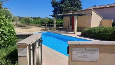 a swimming pool with a sign in front of a house at 225 Chemin des Joncs in Saint-Pierre-de-Vassols